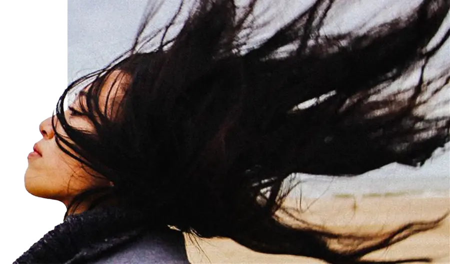 Woman with wind in her hair on the beach